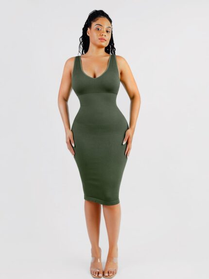 Woman in dark green deep V-neck shaper dress, front view.
