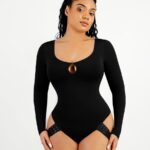Woman in black long-sleeve scoop neck thong bodysuit with droplet cutout, front view.