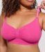 Woman wearing the hot pink seamless shaping bra with adjustable straps, holding the strap.