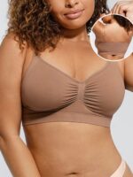 Woman wearing the nude brown seamless shaping bra with adjustable straps, holding the strap.