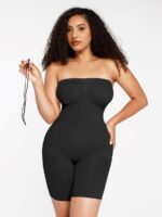 Woman in black strapless butt-lifting bodysuit holding a detachable strap, front view.