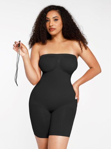 Woman in black strapless butt-lifting bodysuit holding a detachable strap, front view.