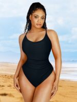 Woman wearing the black pleated tummy-control swimsuit on the beach.