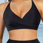 Woman in black cross-front two-piece swimsuit with droplet detail, front view.