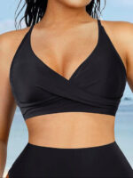Woman in black cross-front two-piece swimsuit with droplet detail, front view.