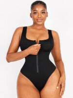 Woman zipping the black tummy-control swimsuit, front view.